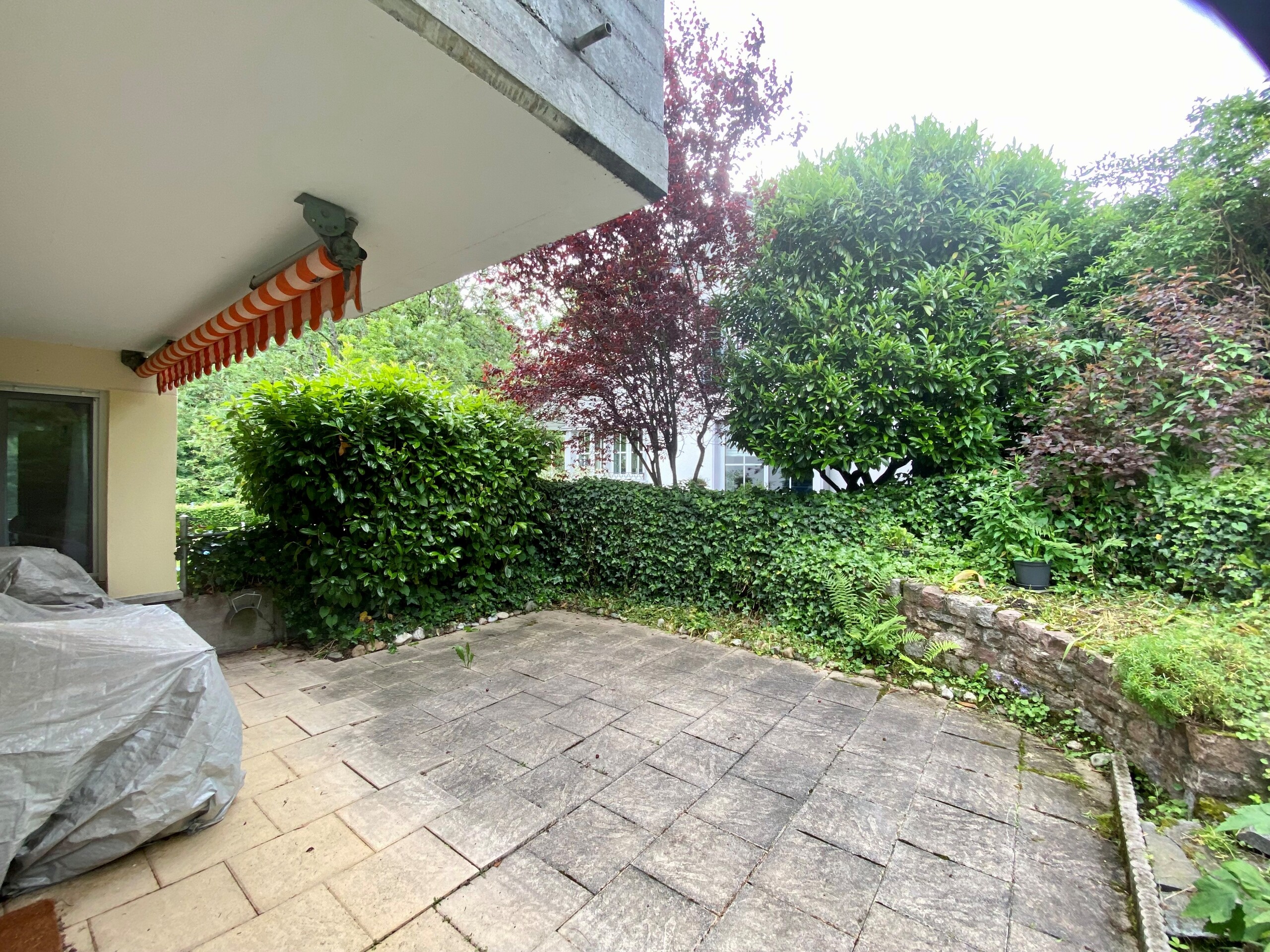 Überdachte Terrasse mit Gartenblick