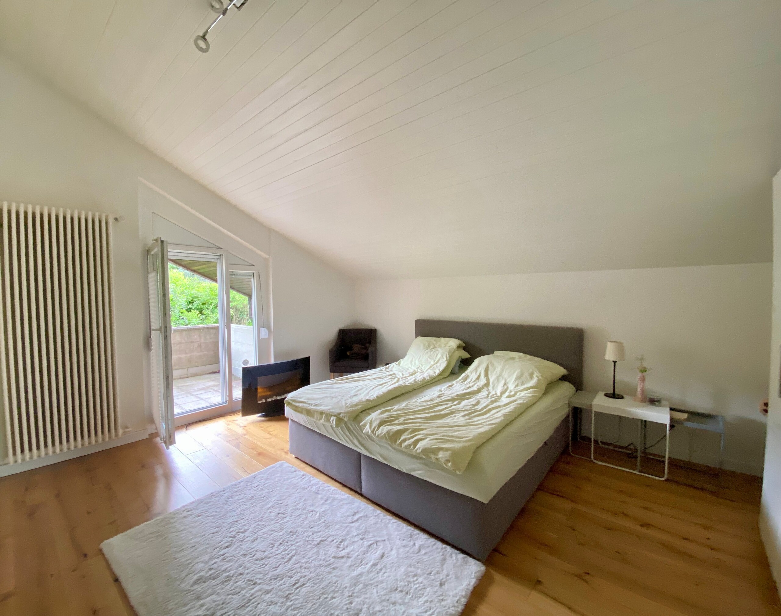 Helles Schlafzimmer mit Dachschräge und Balkonzugang