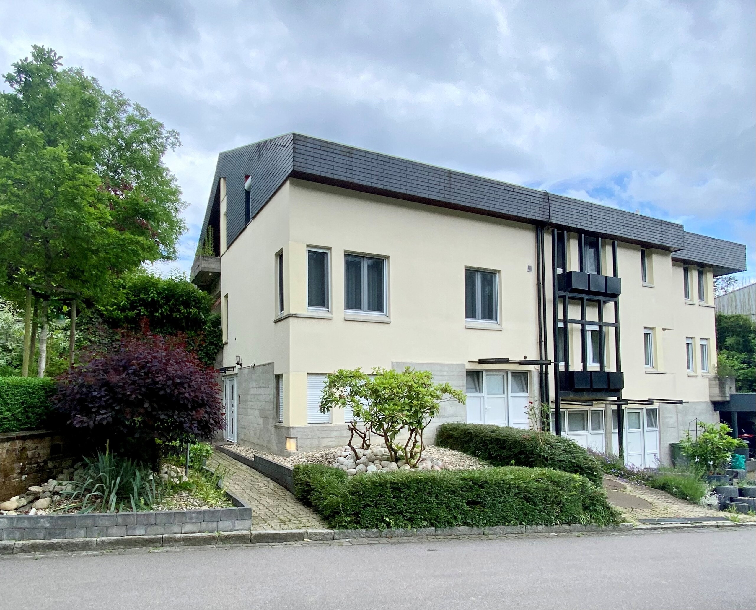 Modernes Mehrfamilienhaus mit Gartenansicht