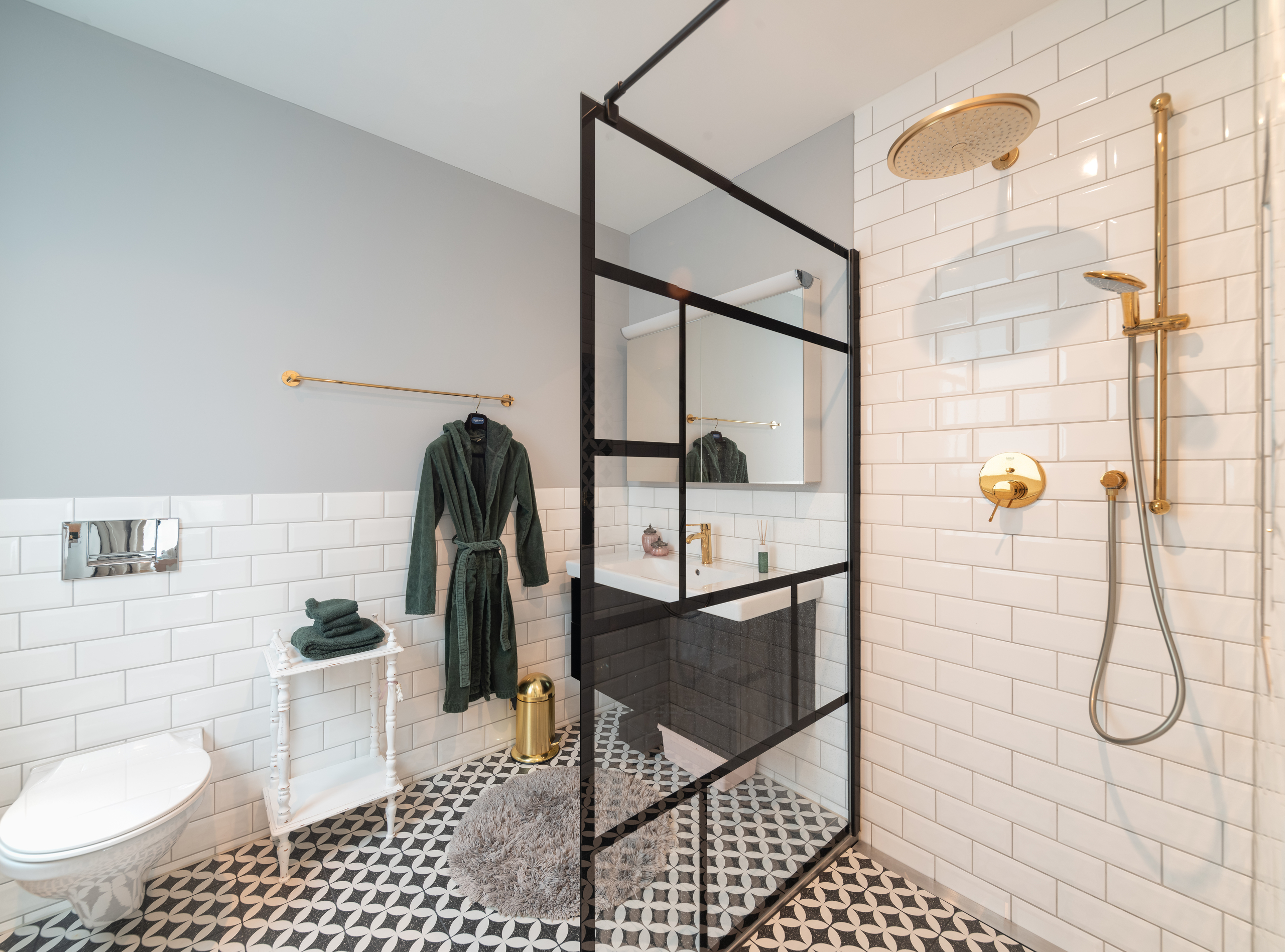 Modernes Badezimmer mit Goldarmaturen und begehbarer Dusche
