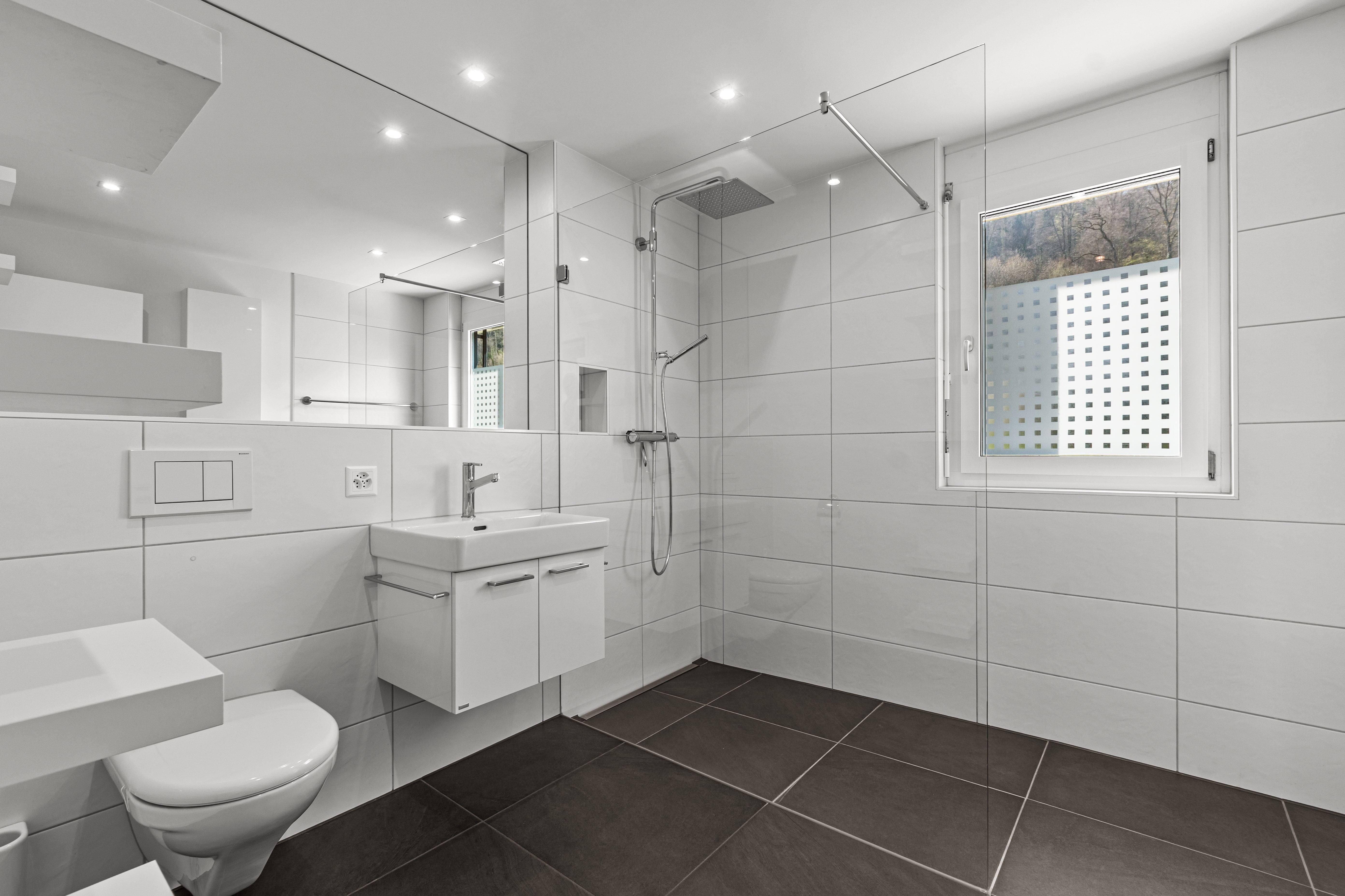 Modernes Badezimmer mit bodengleicher Dusche und WC