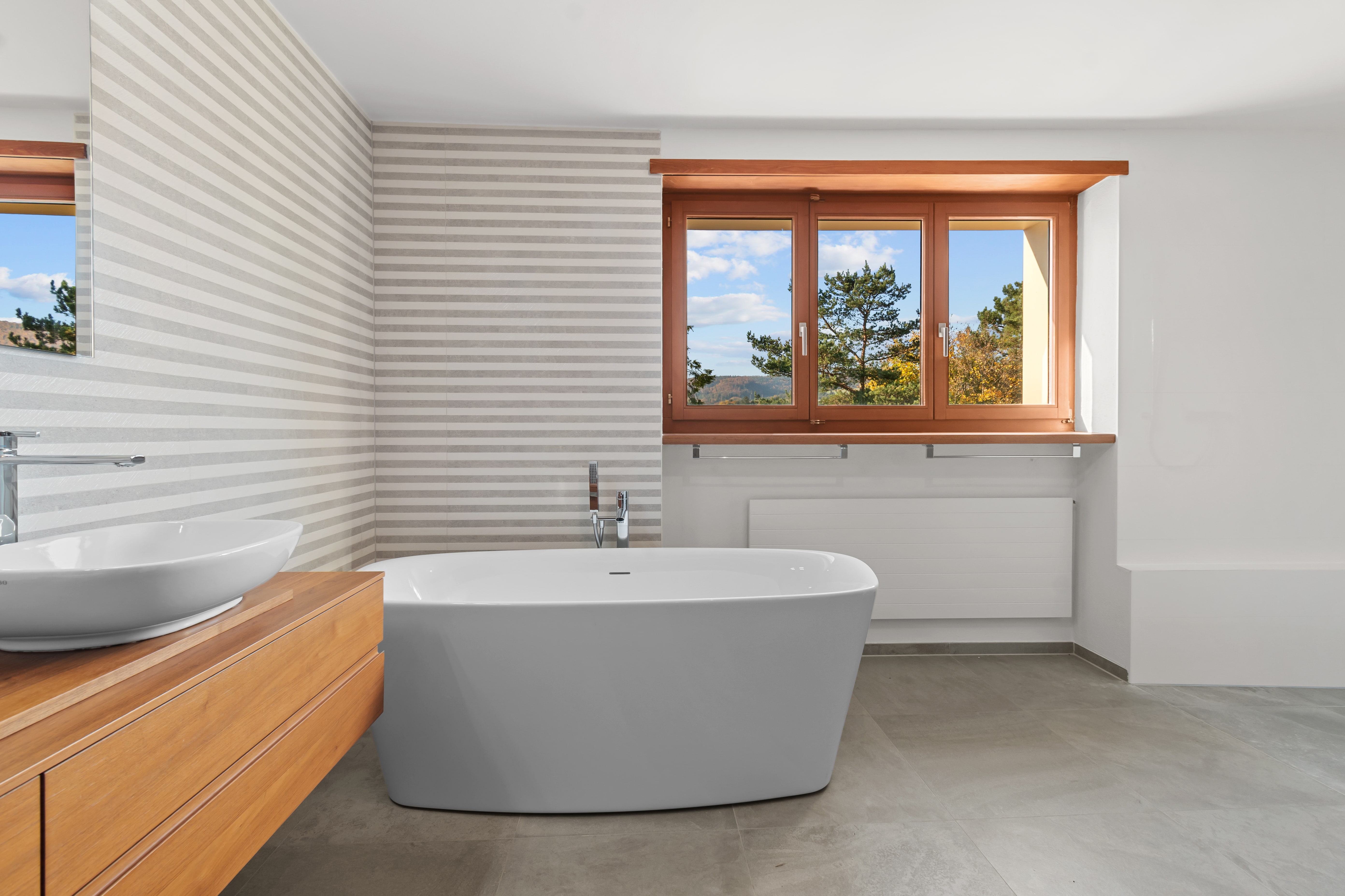 Modernes Badezimmer mit Badewanne und Holzfenster