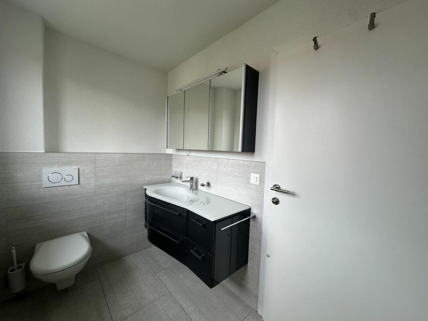 Modernes Badezimmer mit dunklem Waschtisch