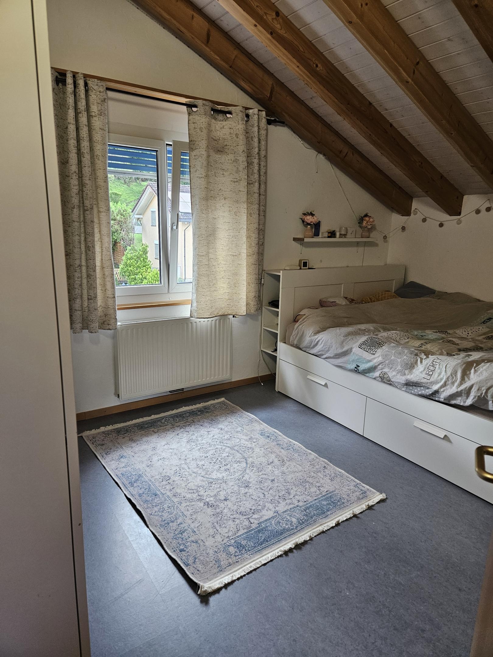 Dachgeschoss-Schlafzimmer mit sichtbaren Holzbalken