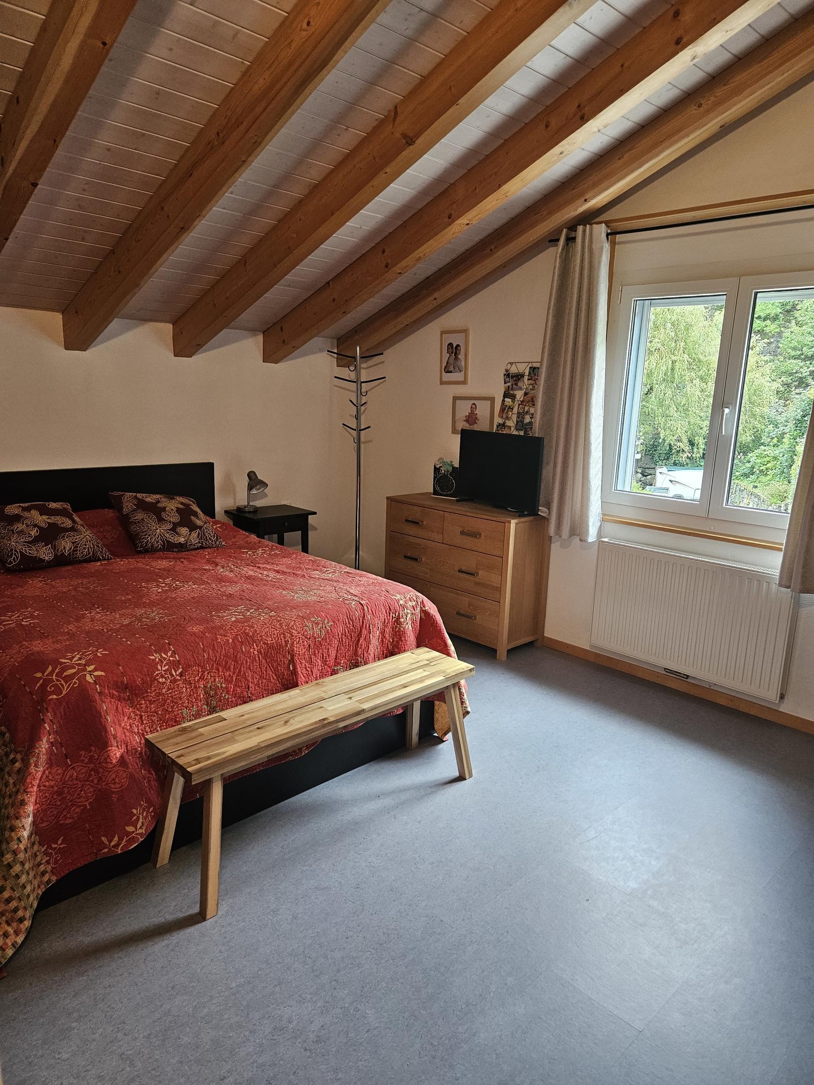Dachgeschoss-Schlafzimmer mit sichtbaren Holzbalken