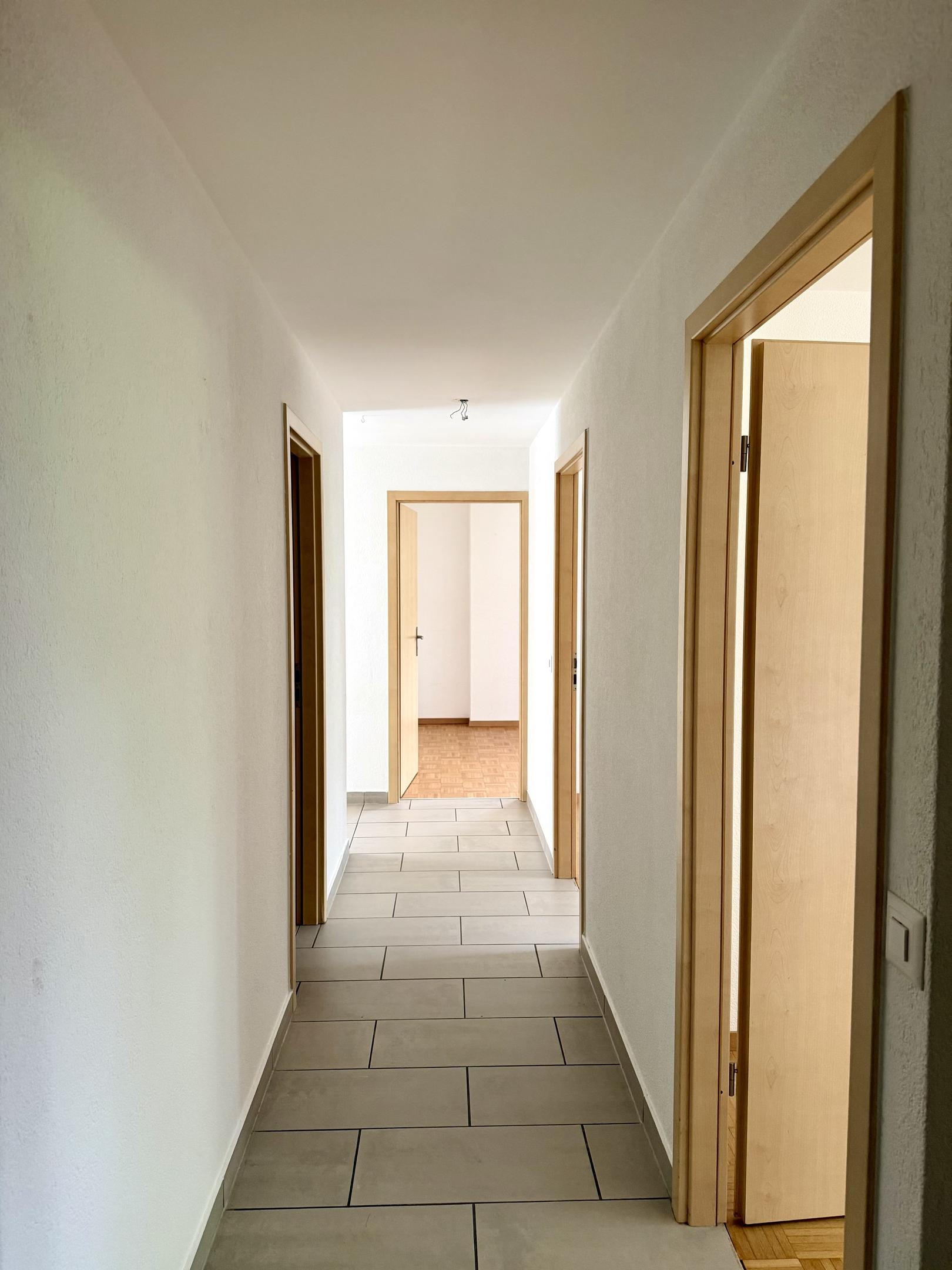 Langer Flur mit mehreren Holztüren