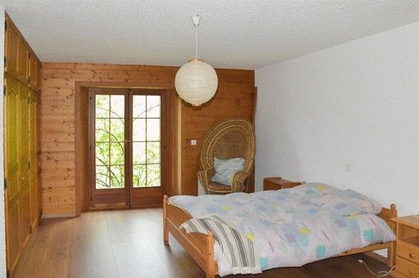 Schlafzimmer mit Holzwand und Doppelterrassentür