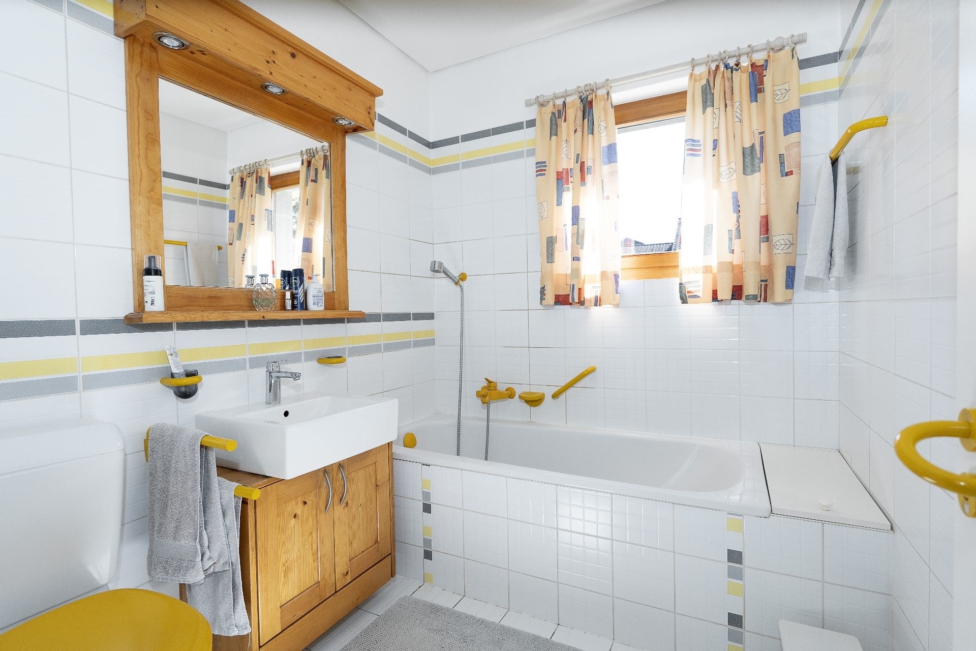 Helles Badezimmer mit Badewanne und Holzwaschtisch