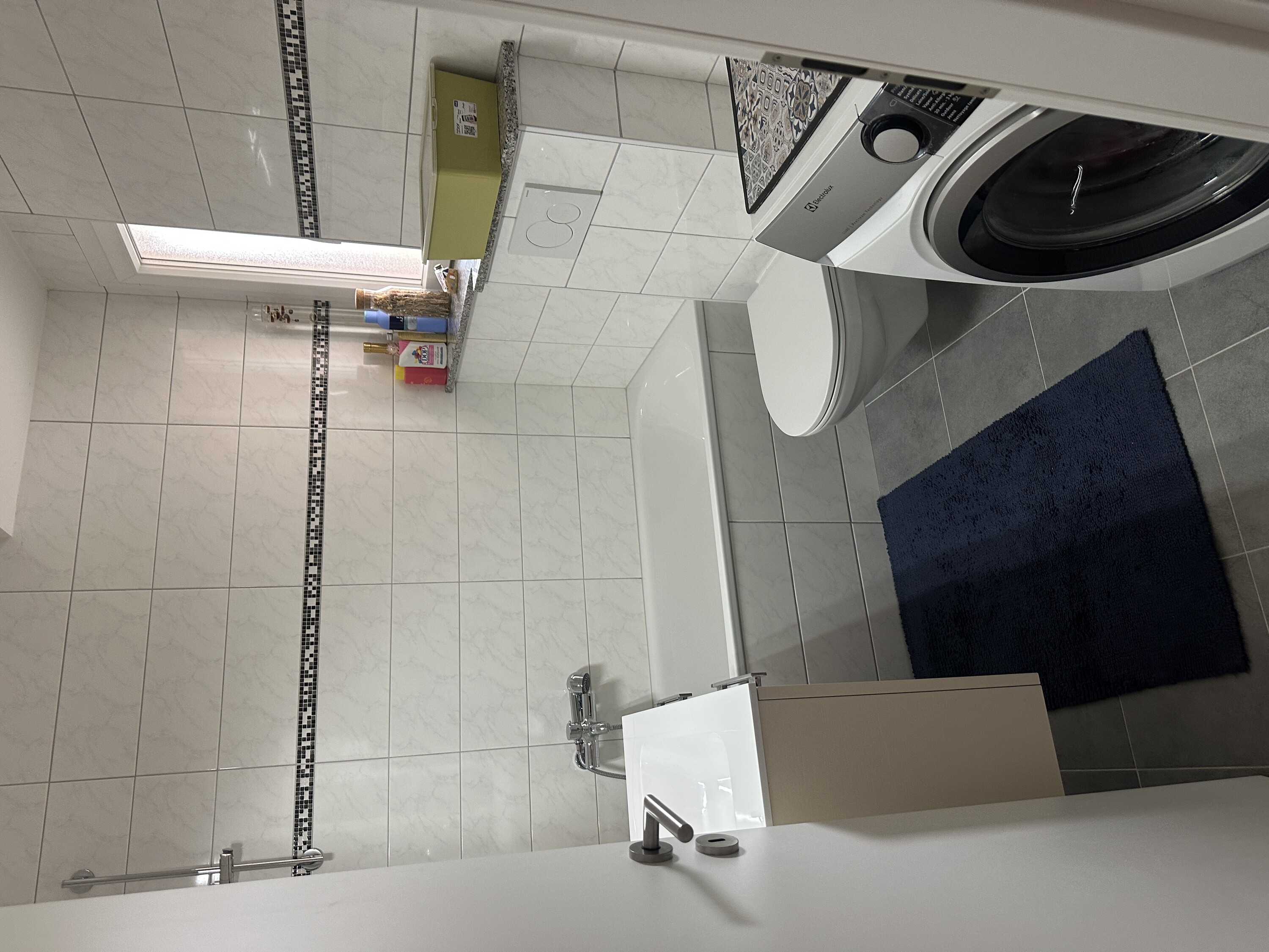 Kleines modernes Bad mit Badewanne und Waschmaschine