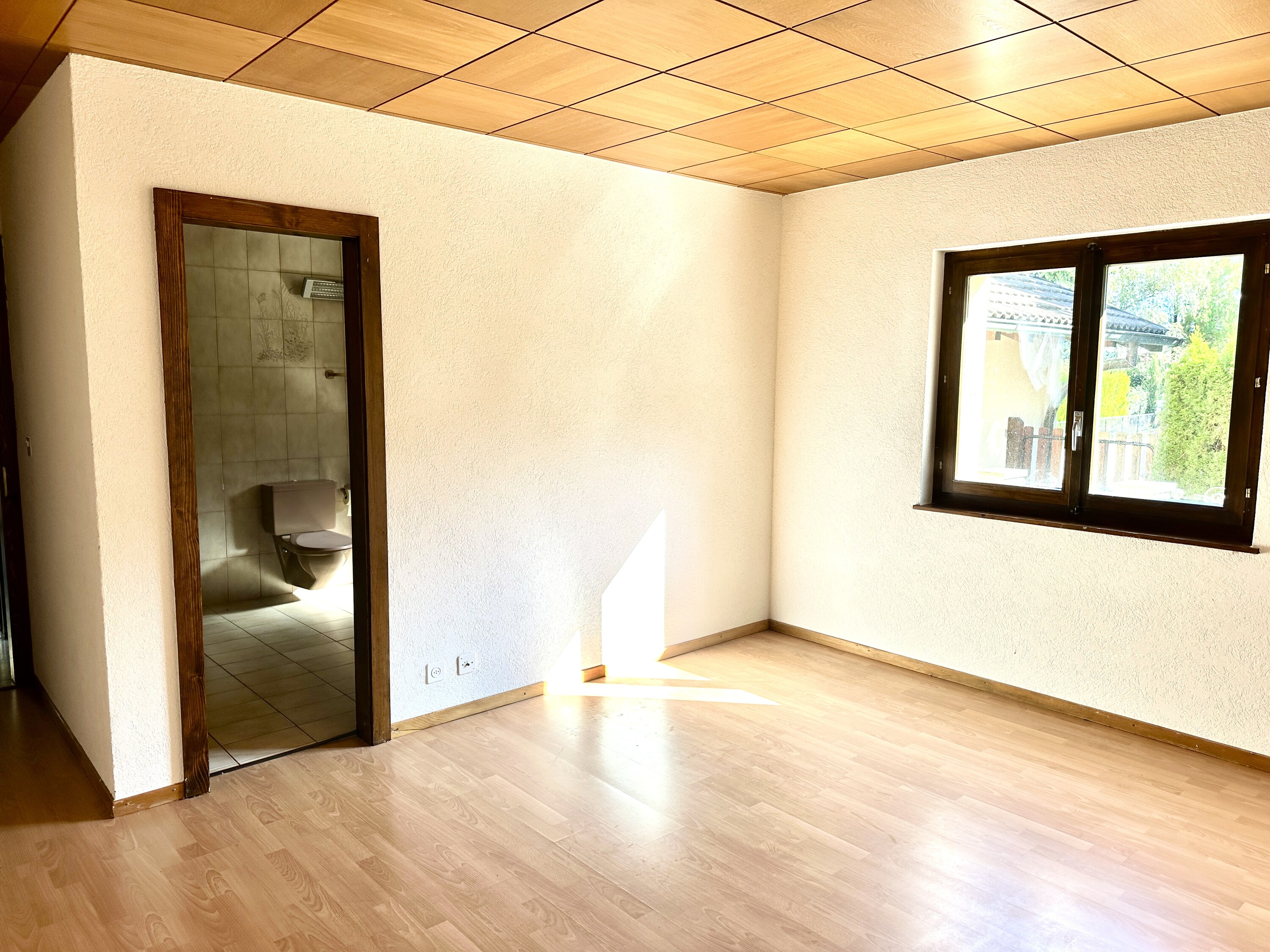 Leerer Raum mit Badezimmerzugang und Fenster