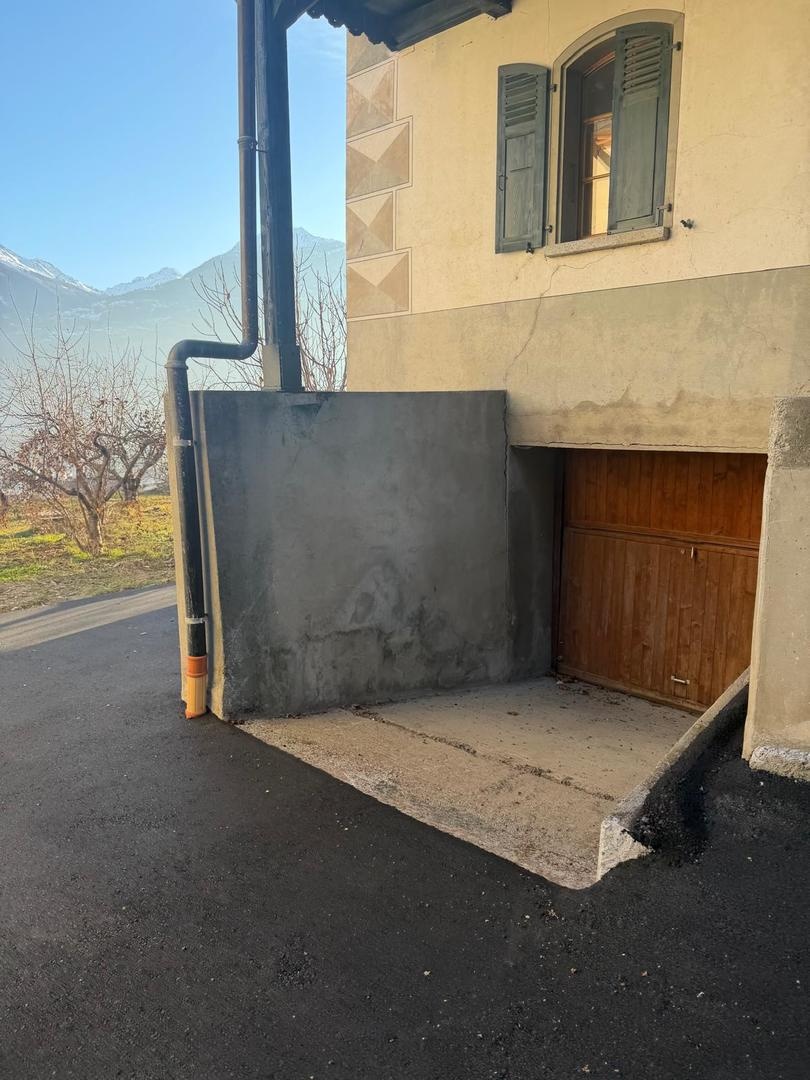 Außenansicht eines Hauses mit Garage und Bergkulisse