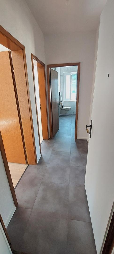 Schmaler Flur mit Blick ins Badezimmer