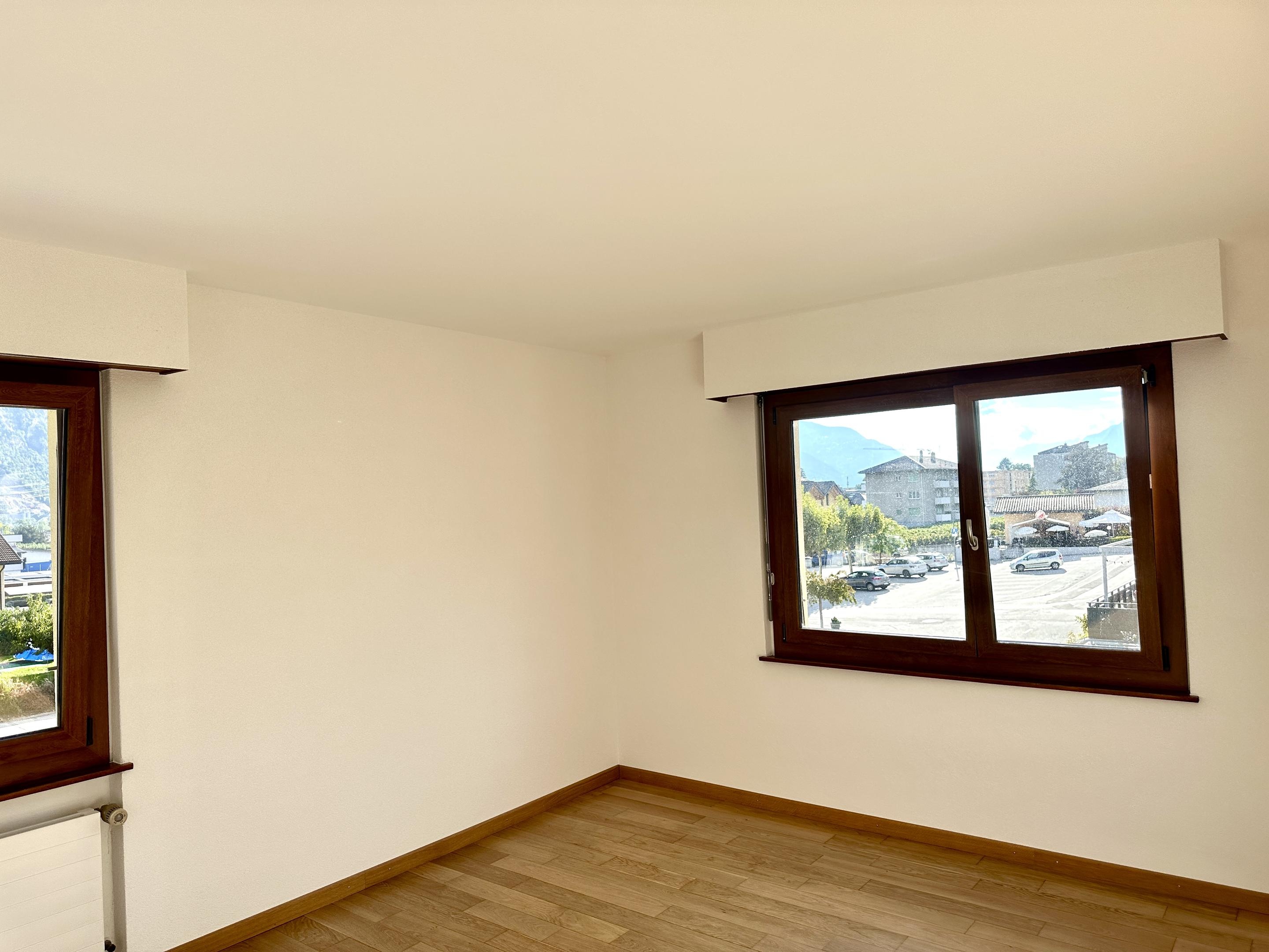 Leerer heller Raum mit Holzfenstern und Blick nach draußen