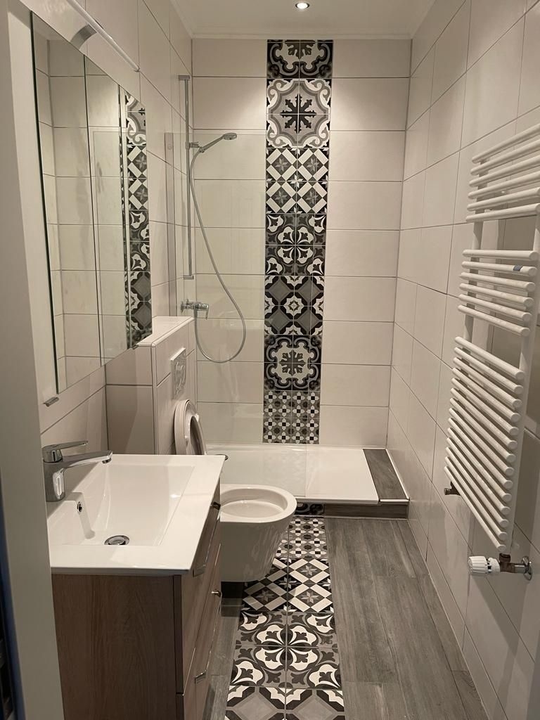 Modernes Badezimmer mit gemustertem Duschbereich