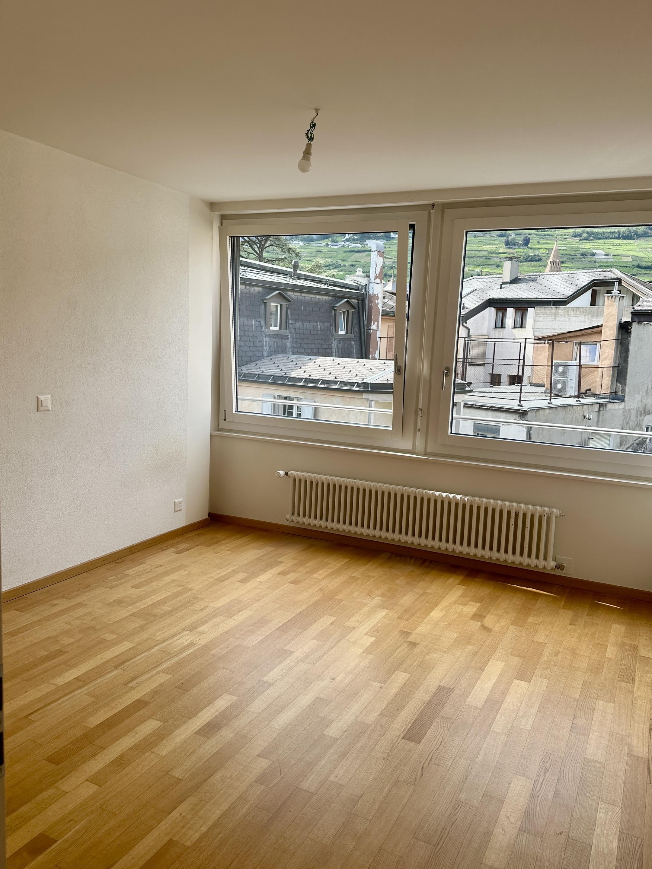 Leeres Zimmer mit großem Fenster und Parkettboden