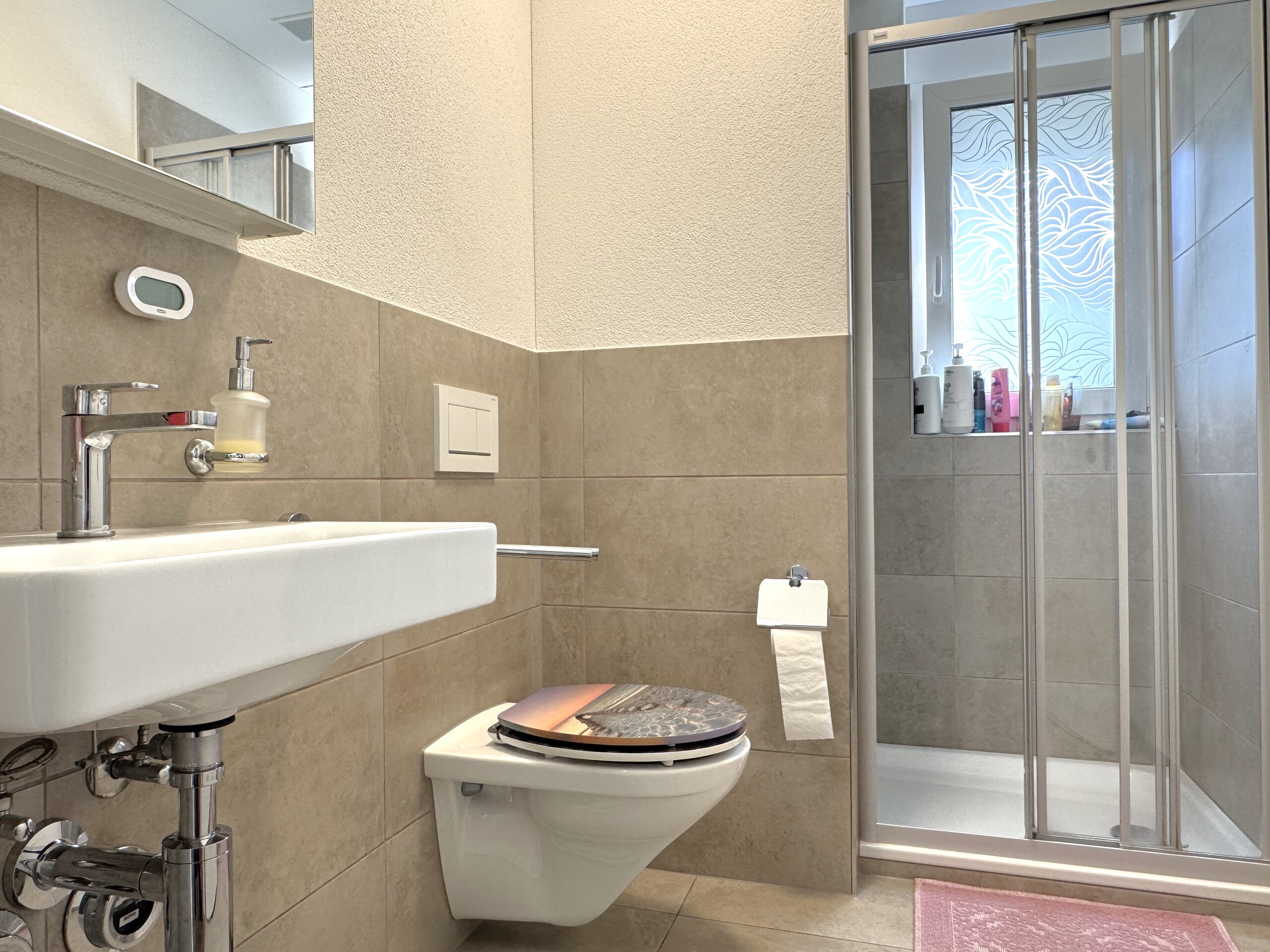 Modernes Badezimmer mit Dusche und wandhängendem WC