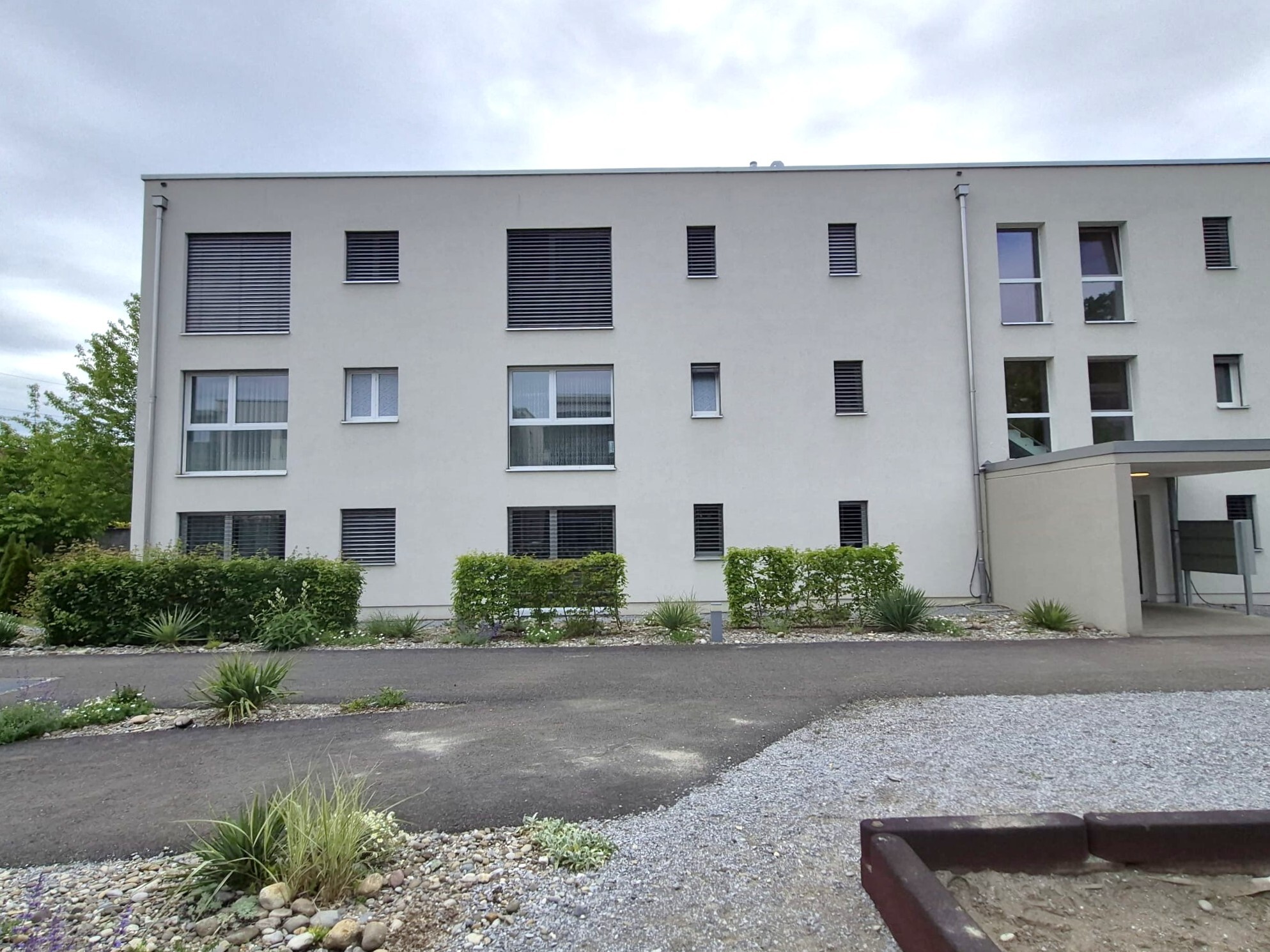 Mehrfamilienhaus mit moderner Fassade und Außenanlage