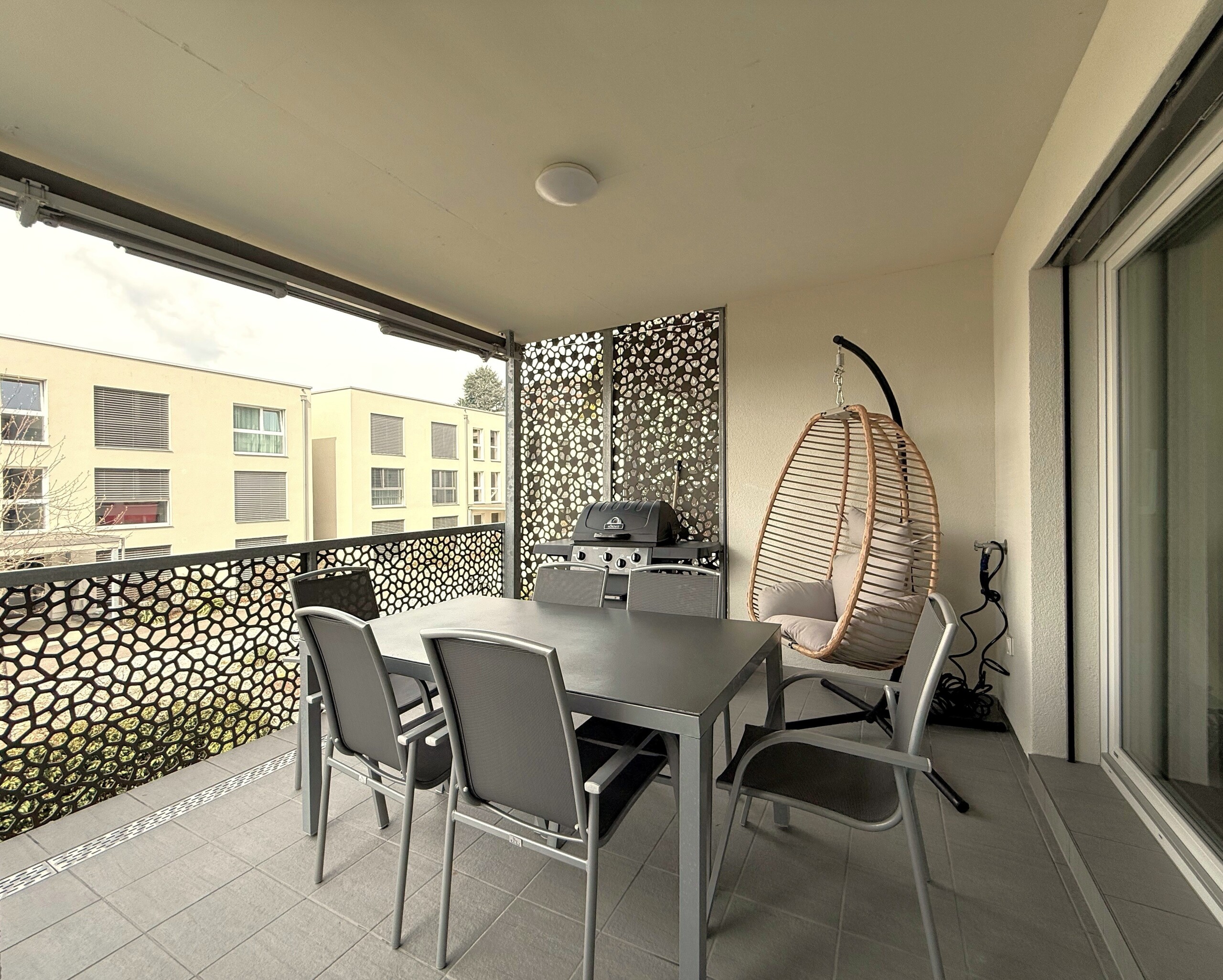 Überdachter Balkon mit Essbereich und Hängesessel