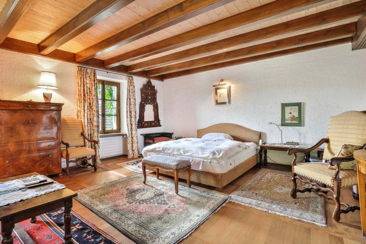 Rustik eingerichtetes Schlafzimmer mit Holzbalkendecke