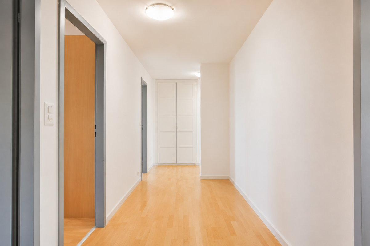 Heller Flur mit Holzboden und weißen Türen