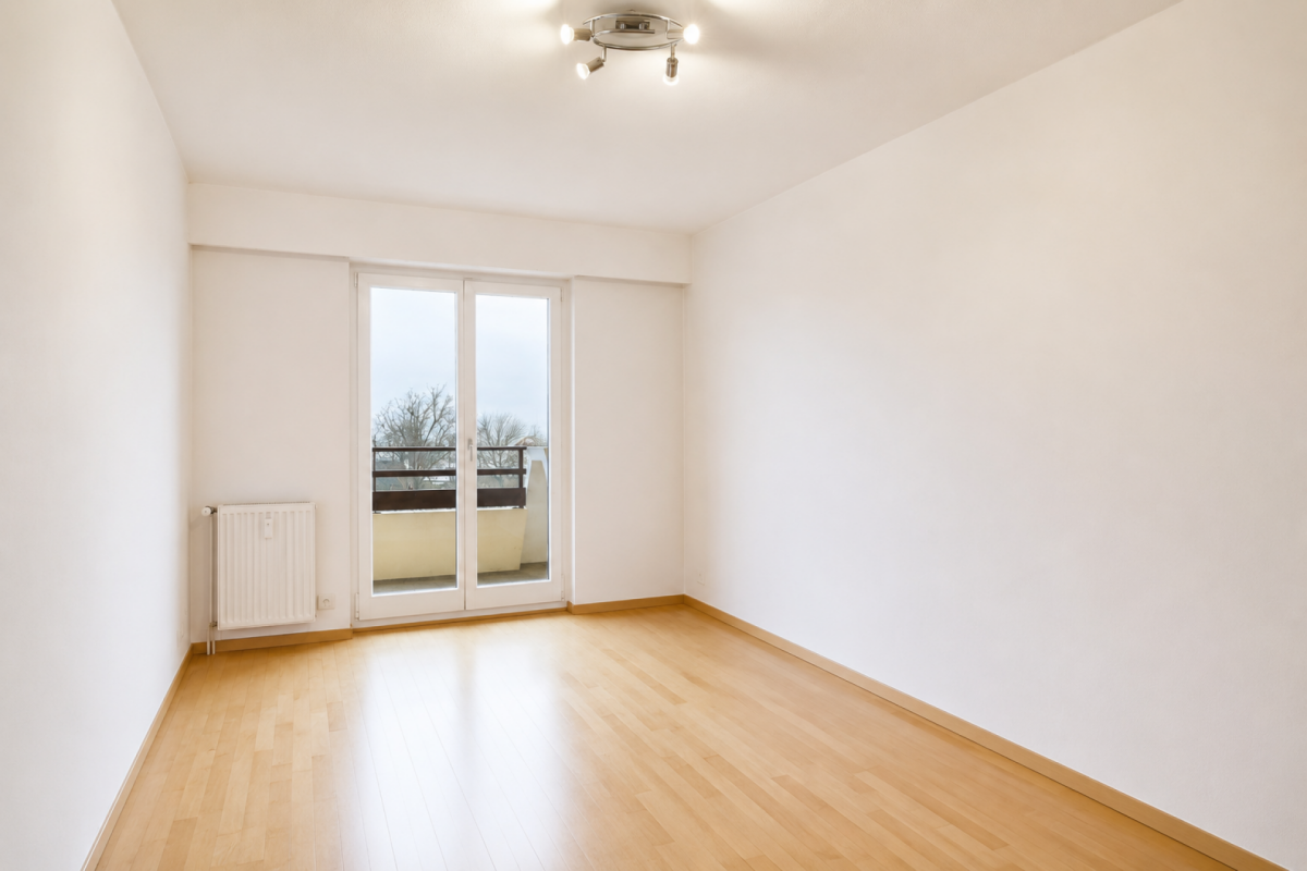 Helles, leeres Zimmer mit Balkonzugang