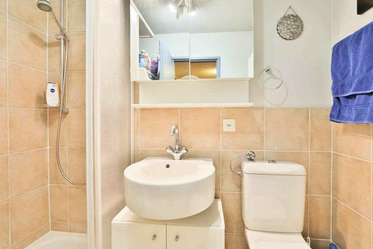 Kleines Badezimmer mit Dusche, Waschbecken und WC