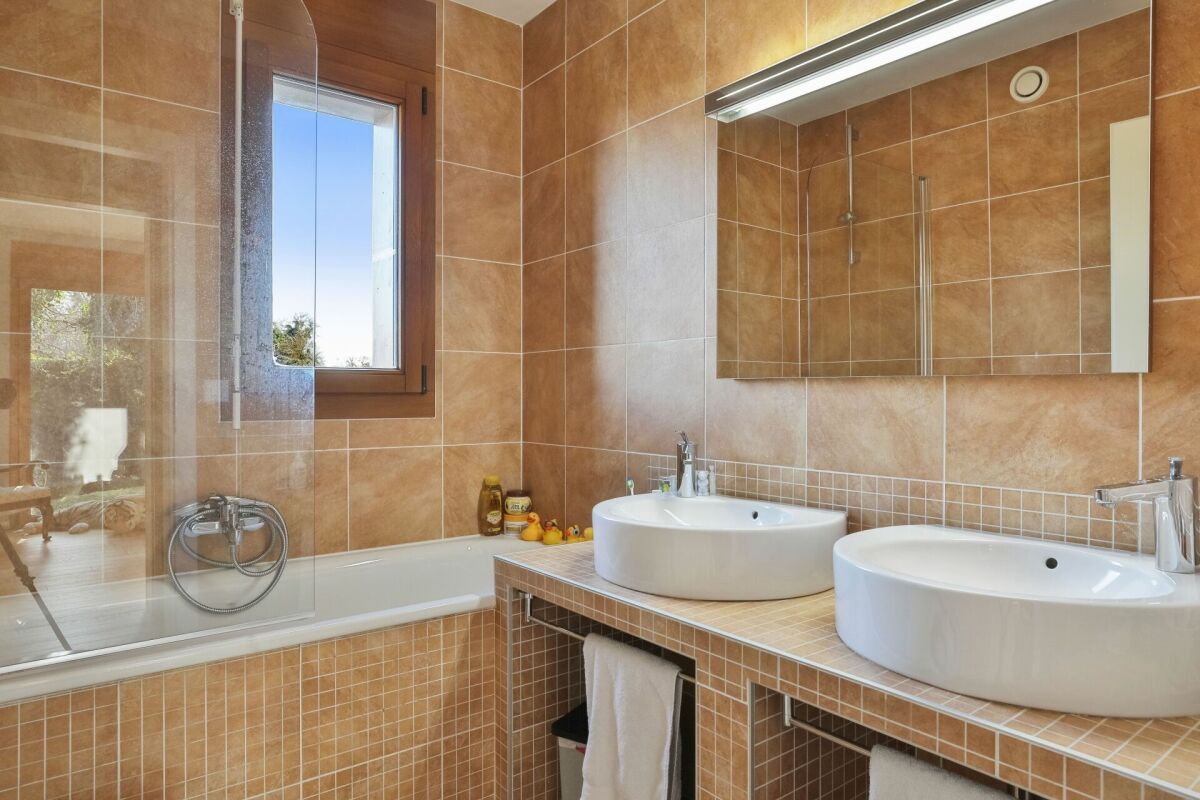 Helles Badezimmer mit Doppelwaschtisch und Badewanne