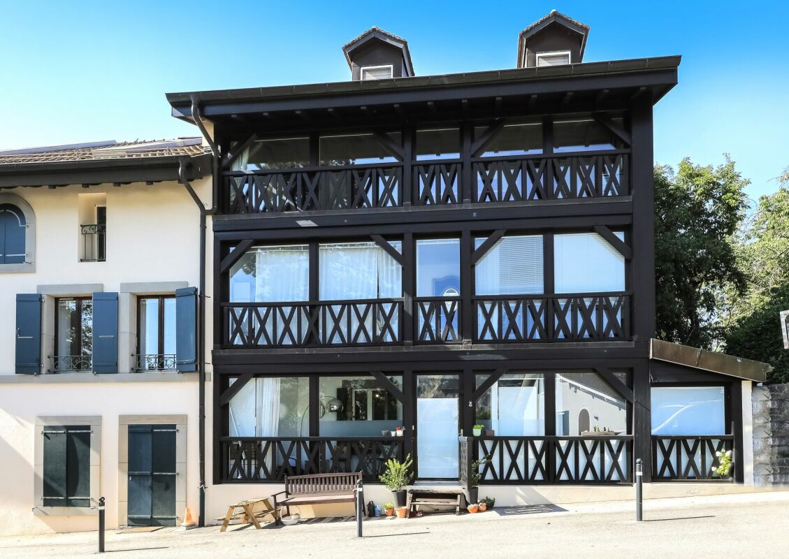 Außenansicht eines mehrgeschossigen Hauses mit dunkler Holzfassade
