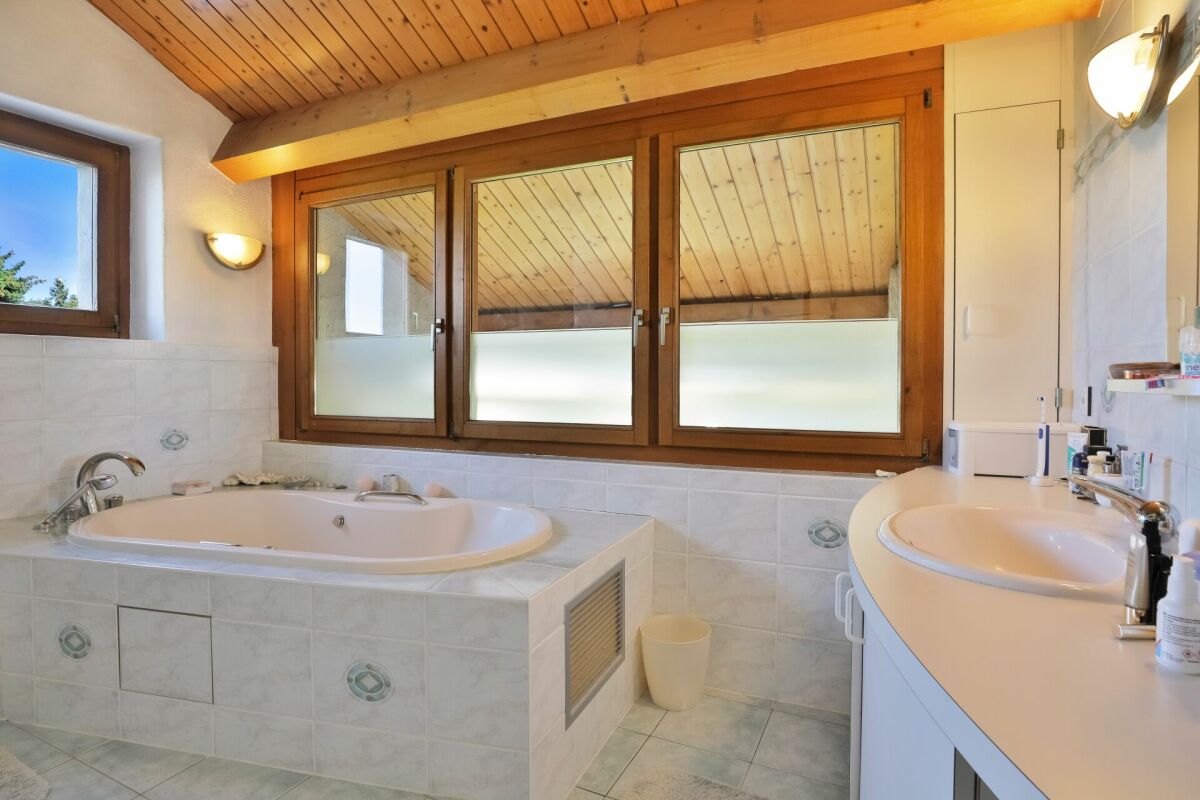 Badezimmer mit Holzdecke und Badewanne