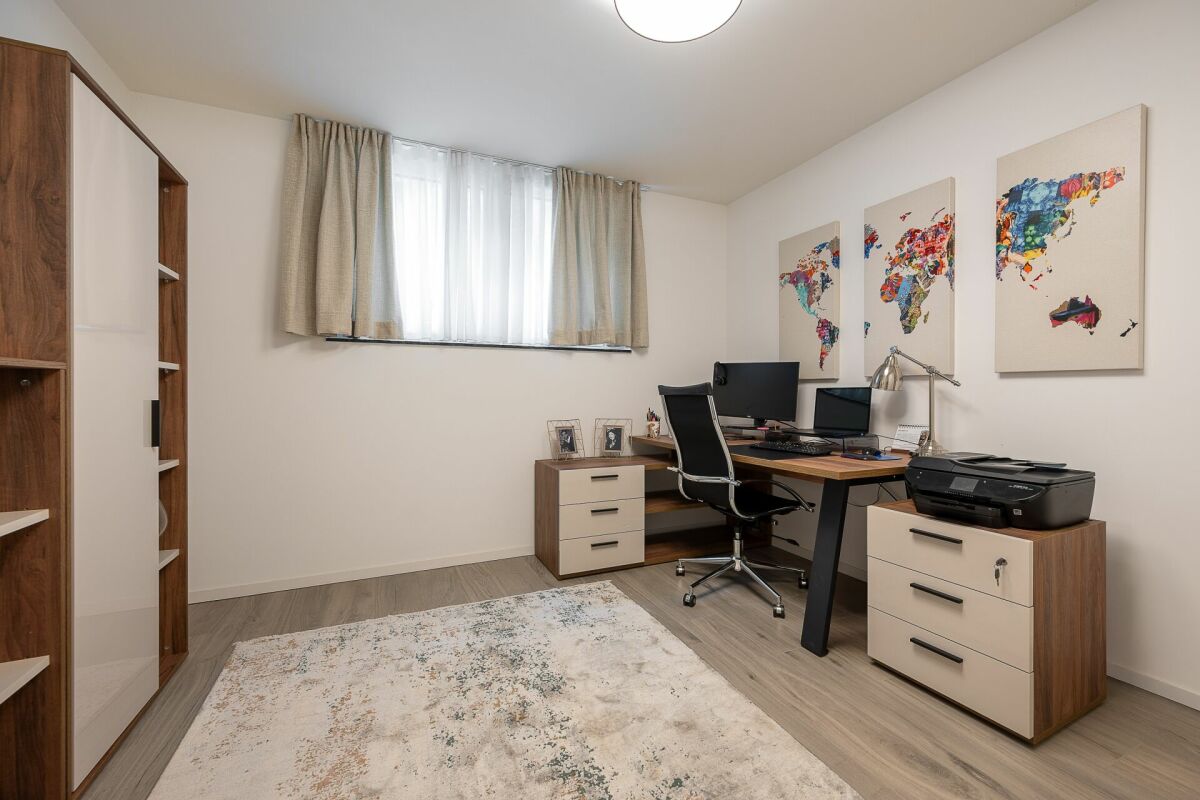 Helles Arbeitszimmer mit Schreibtisch und Schrank