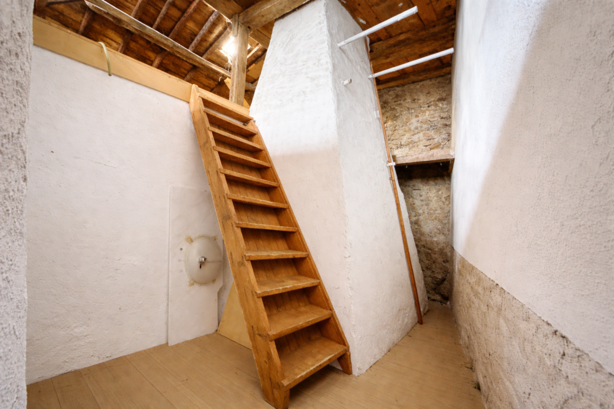Dachboden mit Holztreppe und weißen Wänden