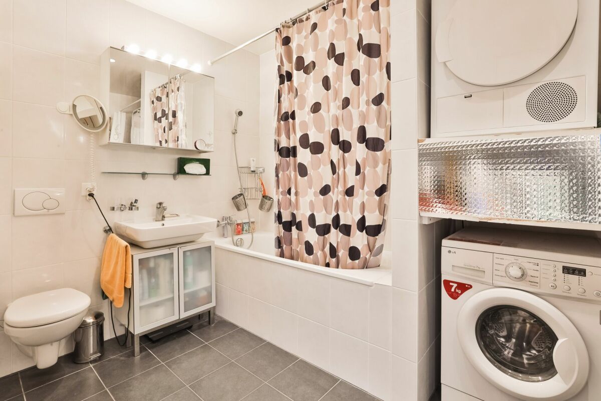 Badezimmer mit Waschmaschine und Badewanne