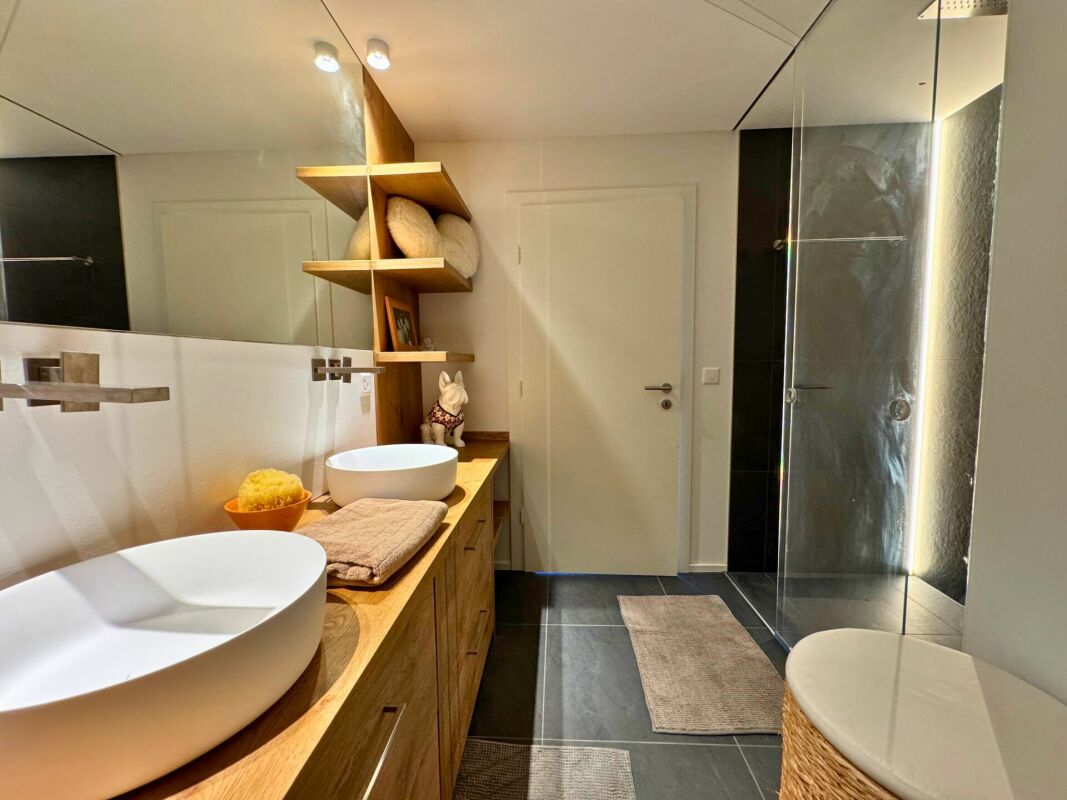 Modernes Badezimmer mit Doppelwaschbecken und Glasdusche