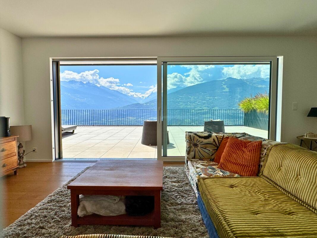 Wohnzimmer mit Panoramablick auf Berge und Terrasse