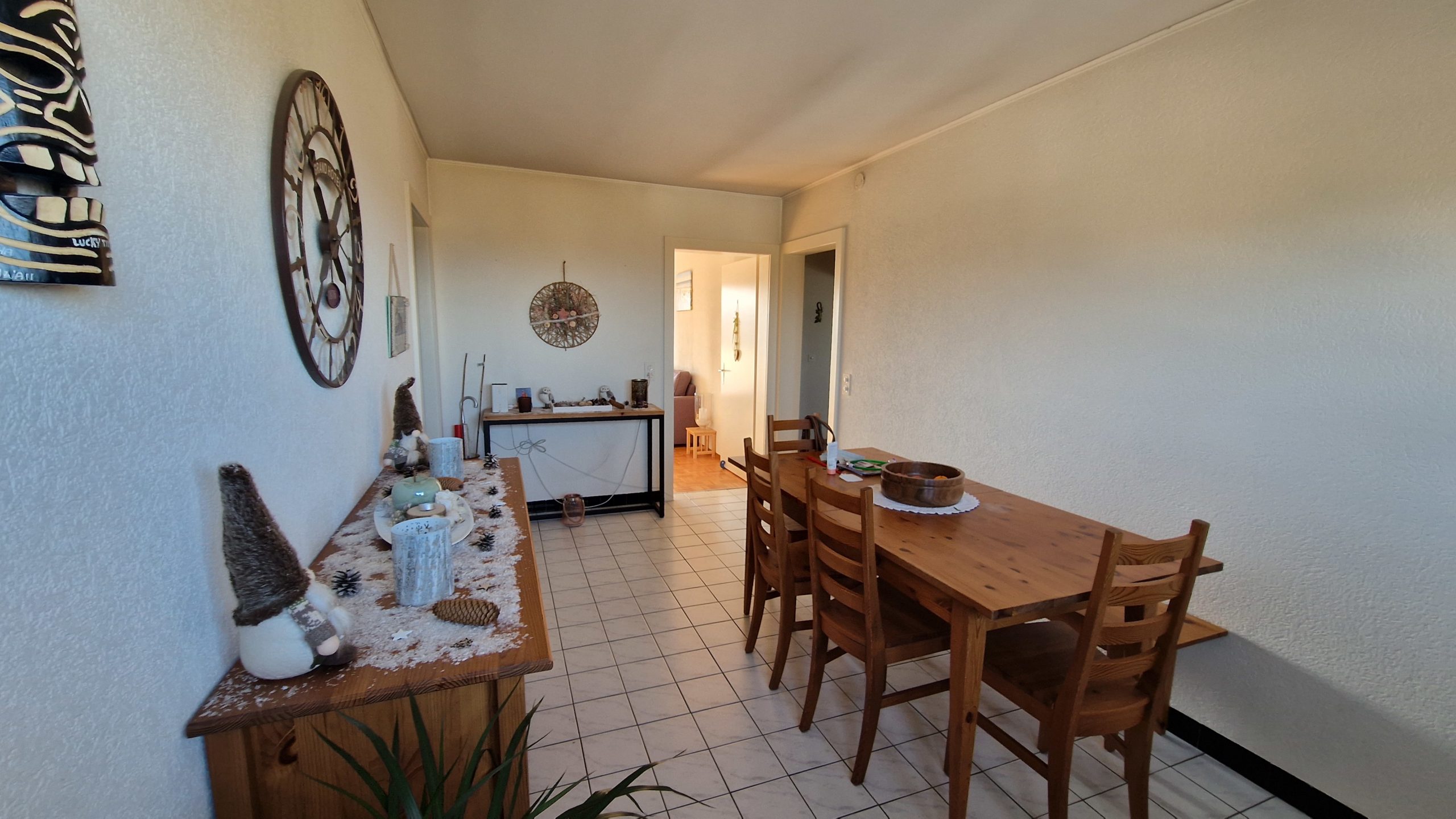 Esszimmer mit Fliesenboden und Holzmöbeln
