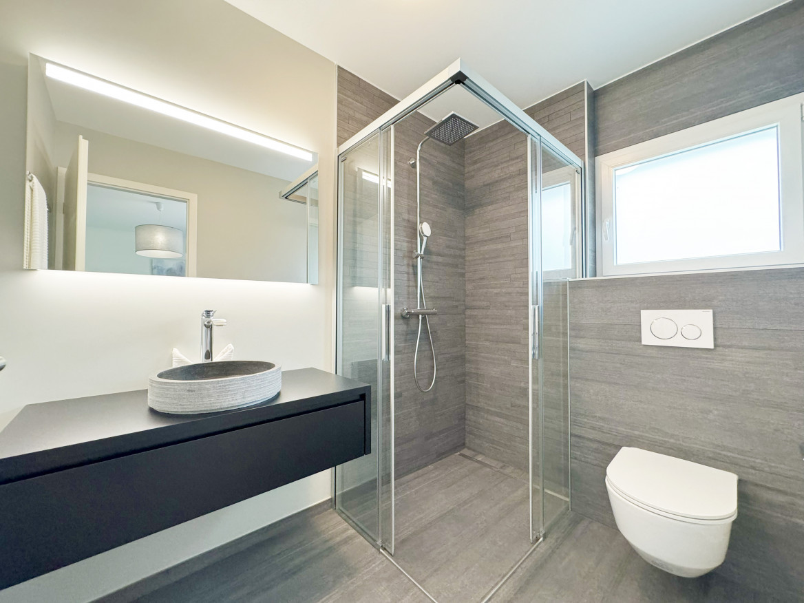 Modernes Badezimmer mit Glasdusche und Wand-WC