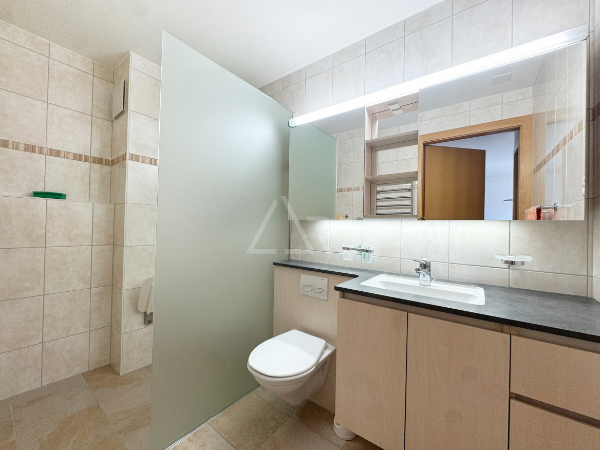 Modernes Badezimmer mit Waschtisch und Duschbereich