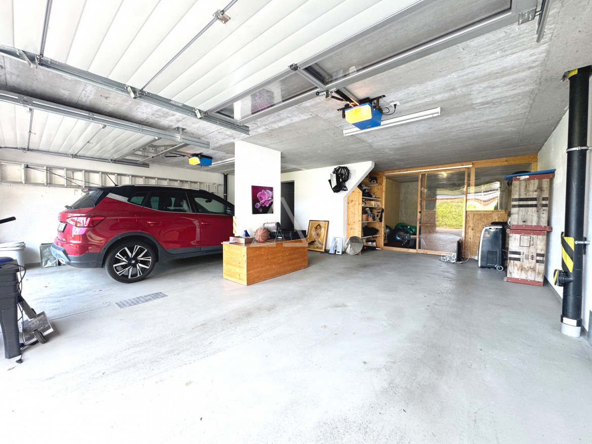 Große Garage mit geparktem SUV und Arbeits-/Lagerbereich