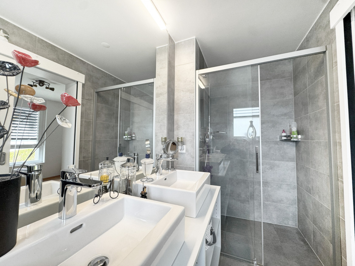 Modernes Badezimmer mit Doppelwaschtisch und Glasdusche