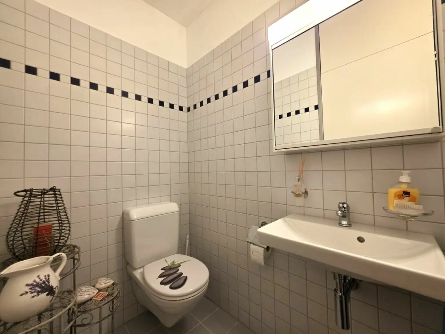 Gäste-WC mit Wandfliesen und Waschbecken