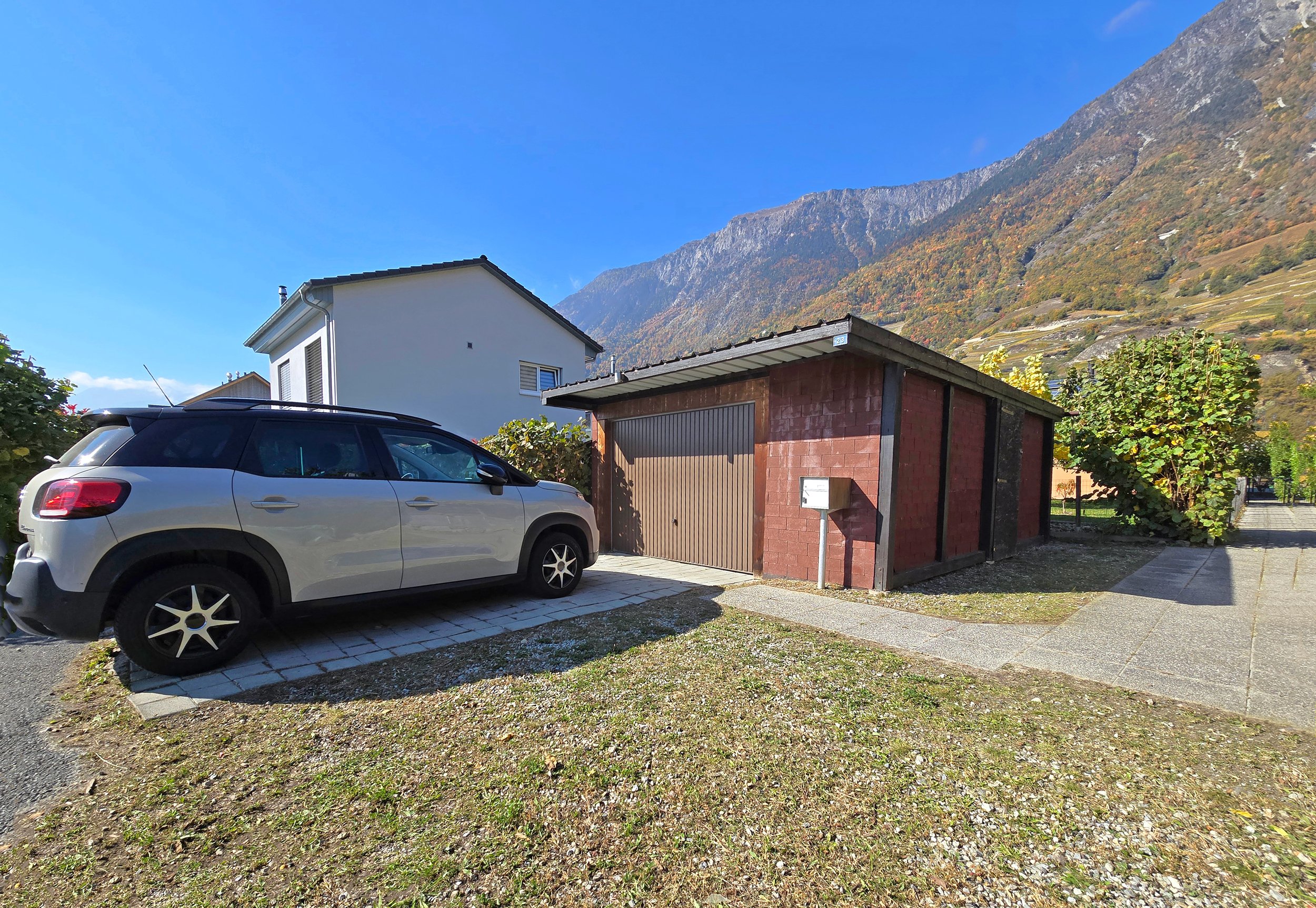 Außenansicht mit Garage und Bergkulisse