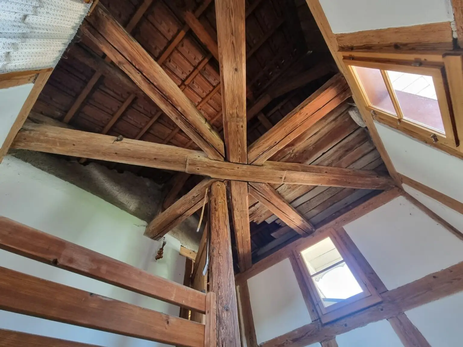Dachstuhl mit sichtbaren Holzbalken und Dachfenstern