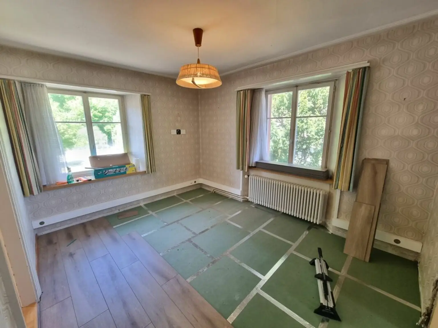 Leeres Zimmer mit großem Fenster und alter Bodenfläche
