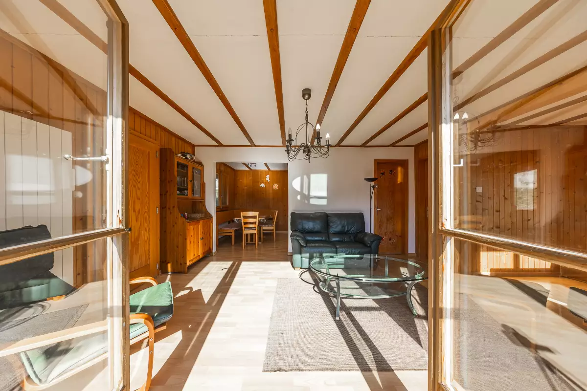 Heller Wohnraum mit Holzvertäfelung und Glasfront