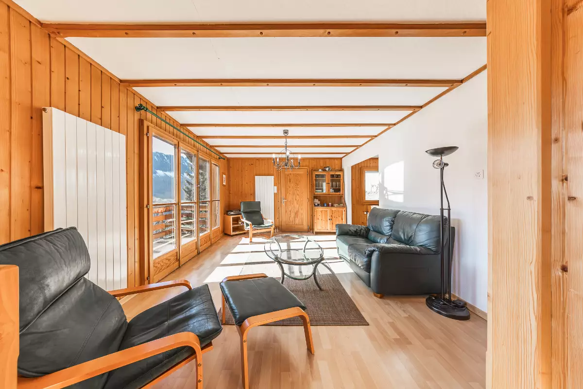 Helles Wohnzimmer mit Holzvertäfelung und Bergblick