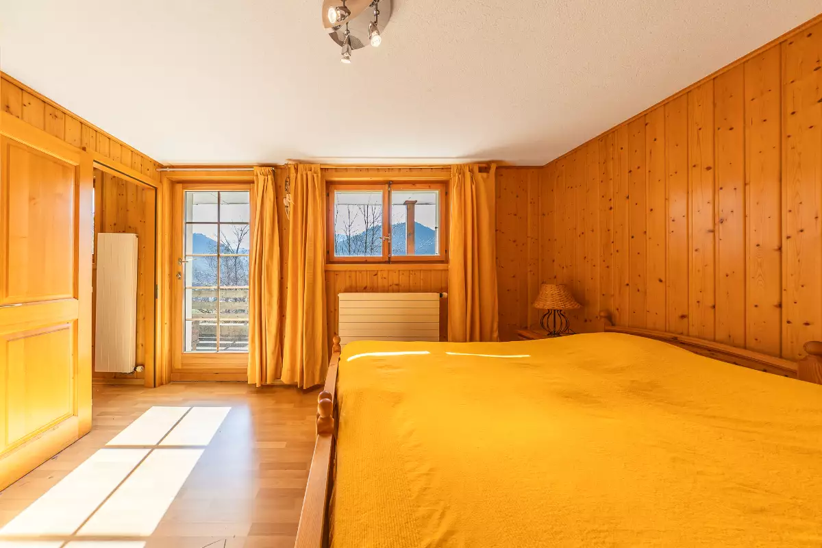 Gemütliches Schlafzimmer mit Holzverkleidung und Bergblick