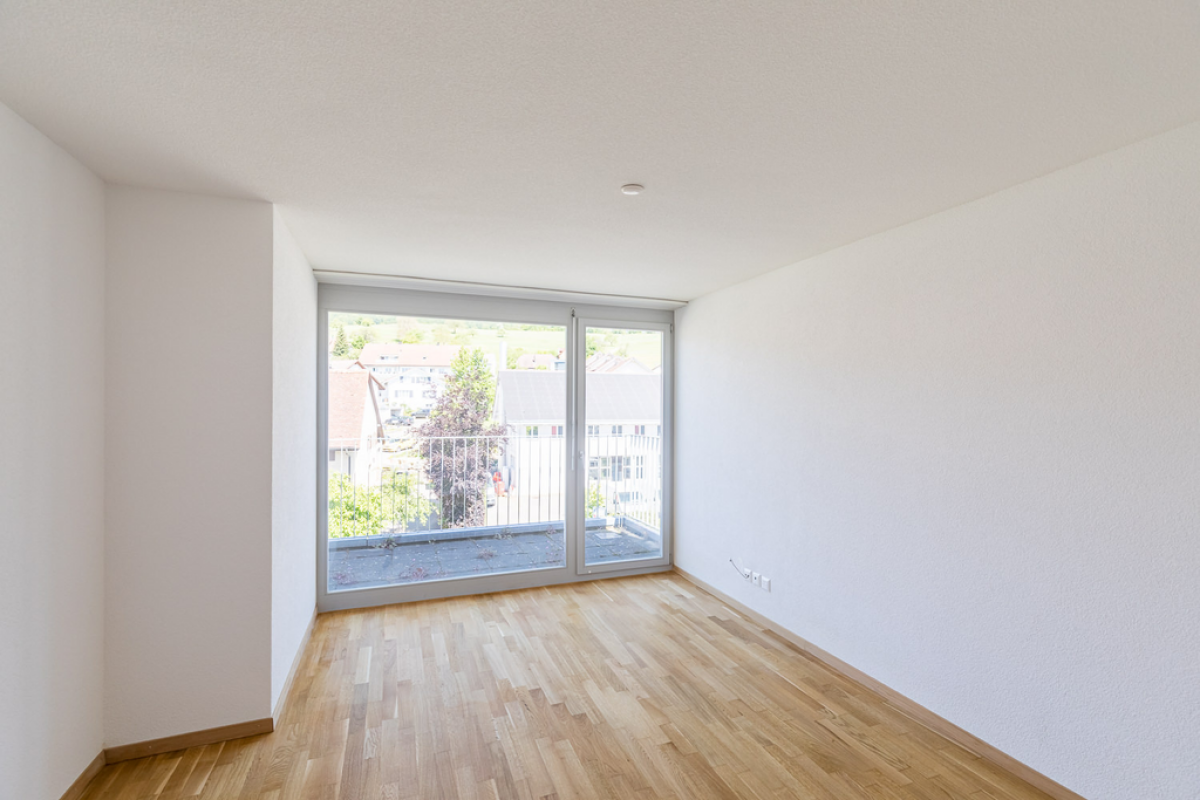 Heller, leerer Wohnraum mit Balkonfenster