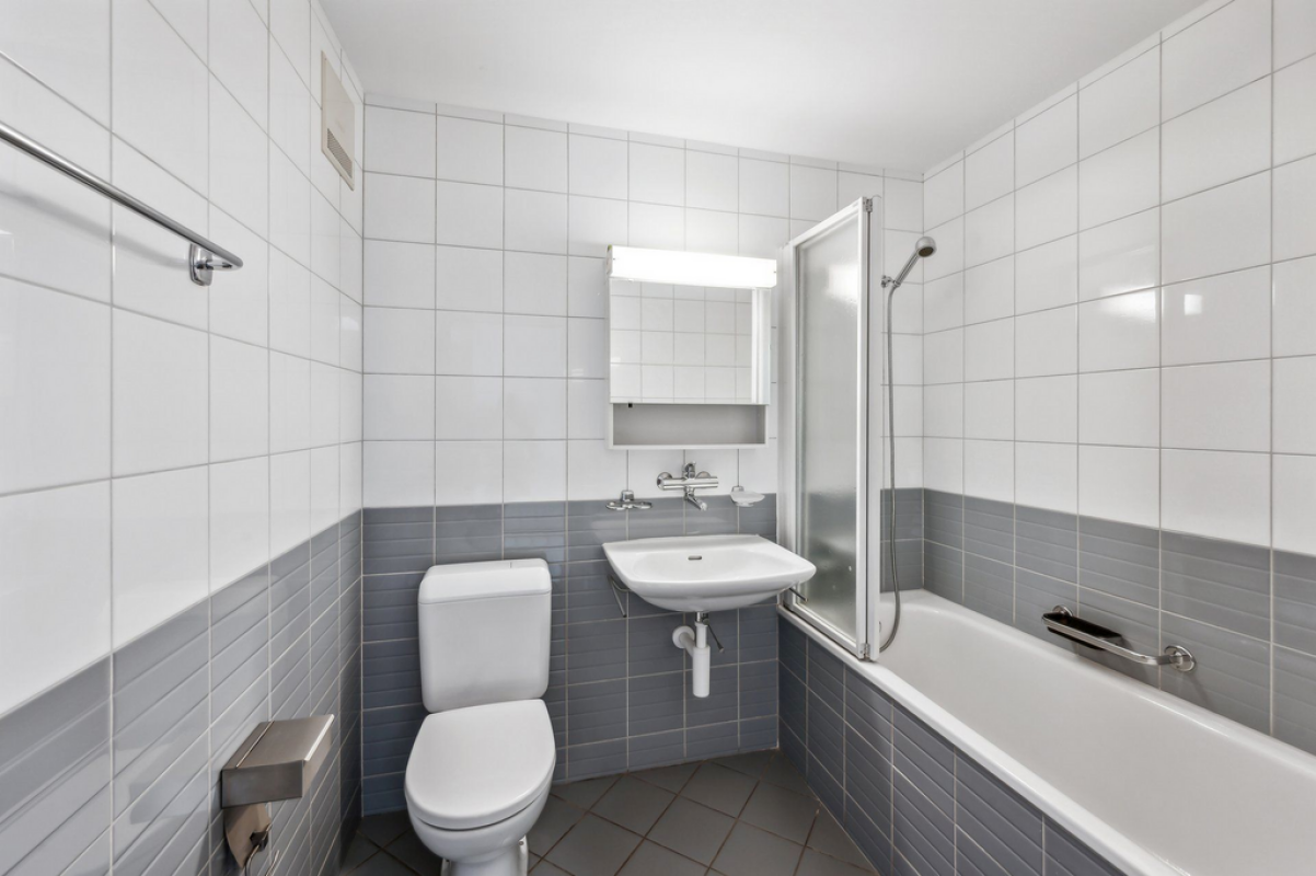 Kleines, helles Badezimmer mit Wanne, Waschbecken und WC