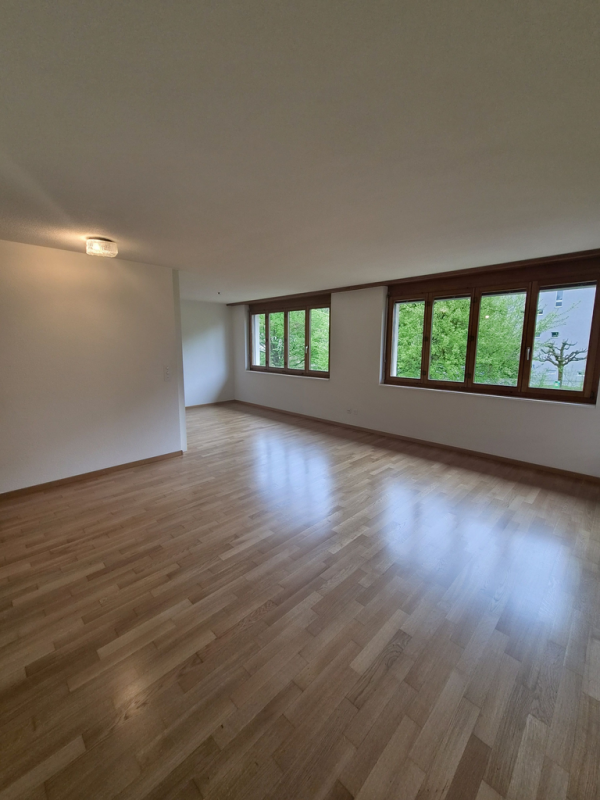 Heller leerer Wohnraum mit Holzfenstern