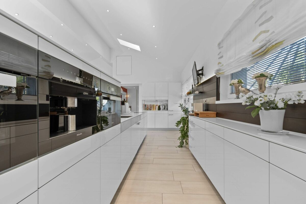 Moderne weiße Küche mit glänzenden Fronten